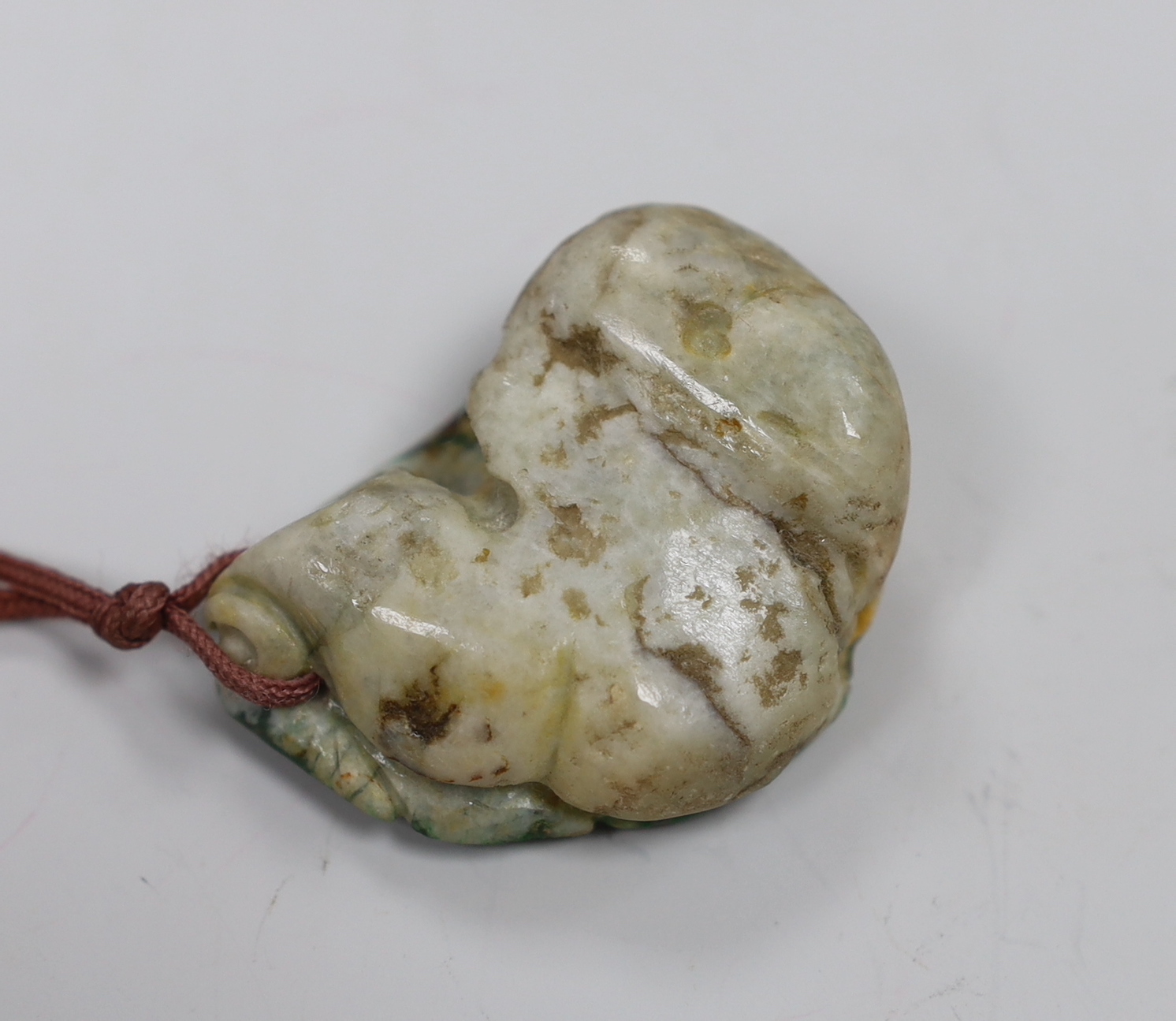 Two jadeite pendants and a handle tip
